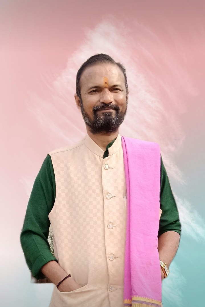 Portrait of Vipul Bhai Bhatt wearing a cream vest, green kurta and pink shawl with a tilak on his forehead